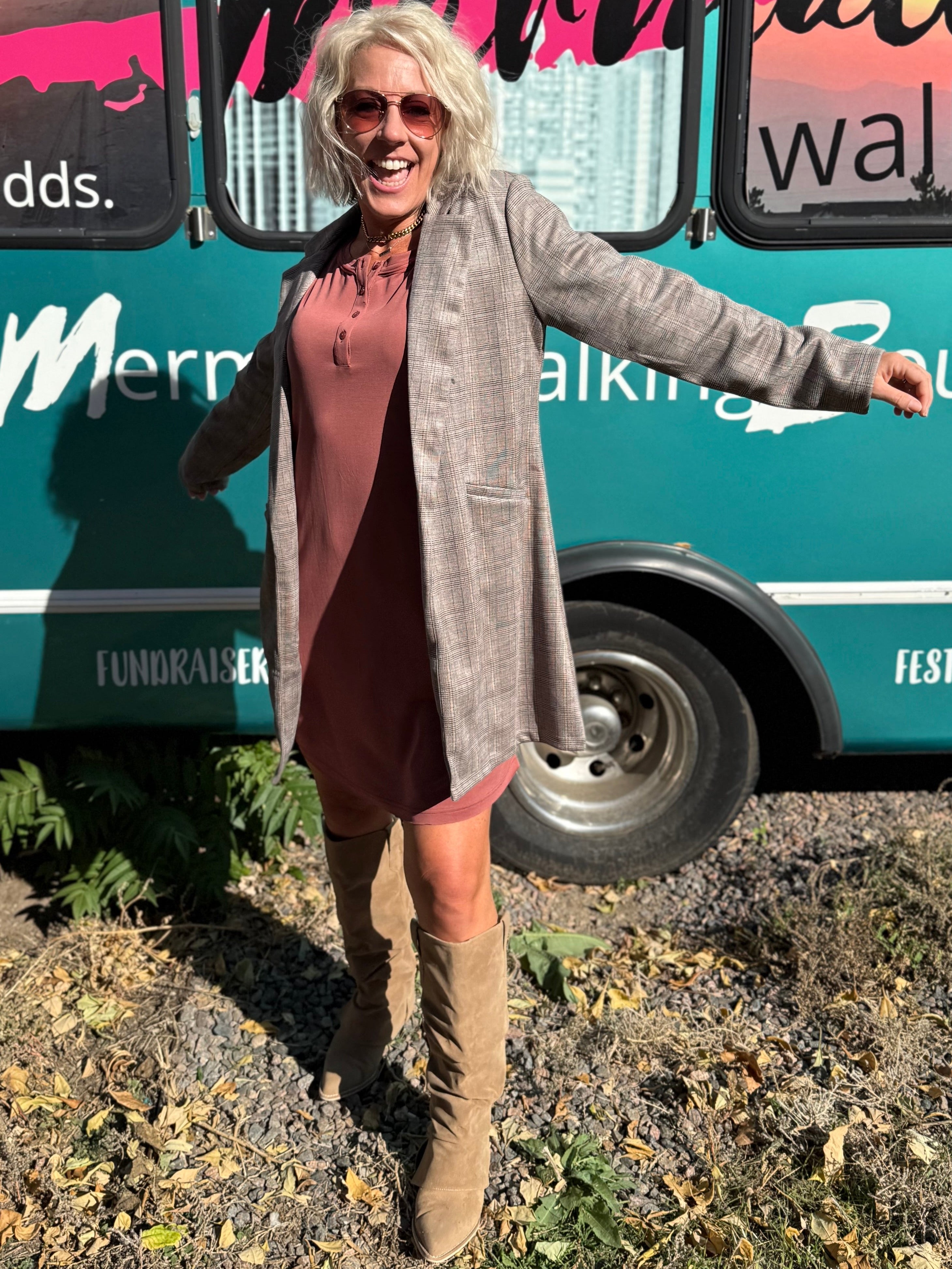 Woman standing in front of a teal bus with 'Mermaid Walking' branding.