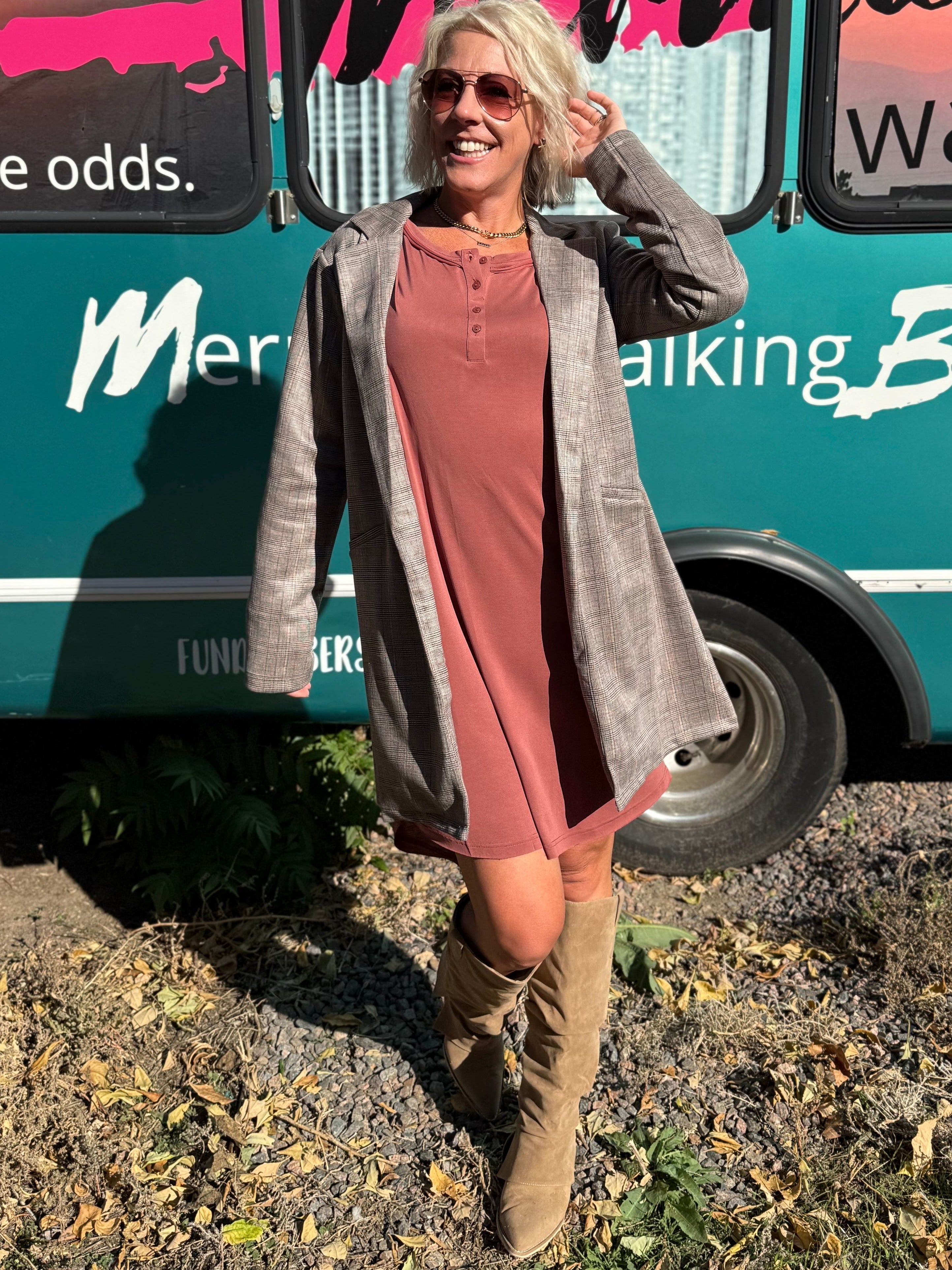 Woman standing in front of a teal bus with 'Mermaid Walking' branding.