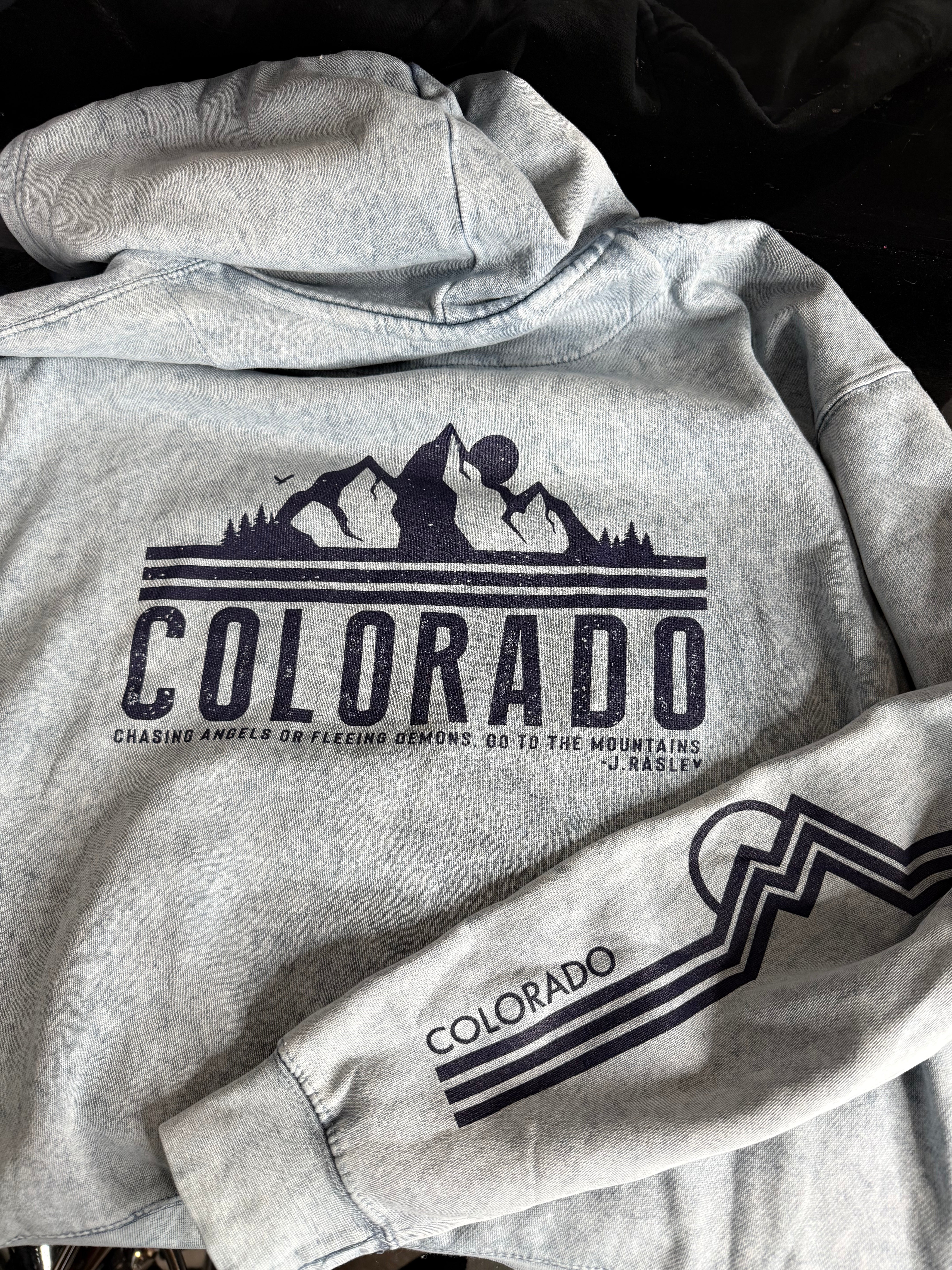 Blue mineral wash sweatshirt with 'Colorado' and mountain graphic on a dark background