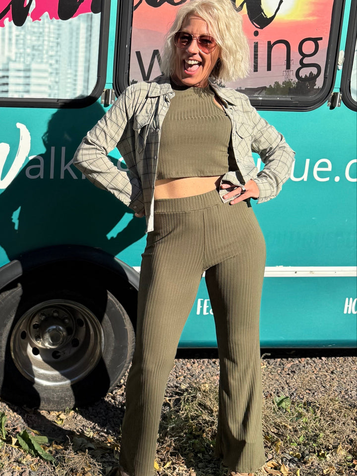 Woman standing in front of a teal bus with &
