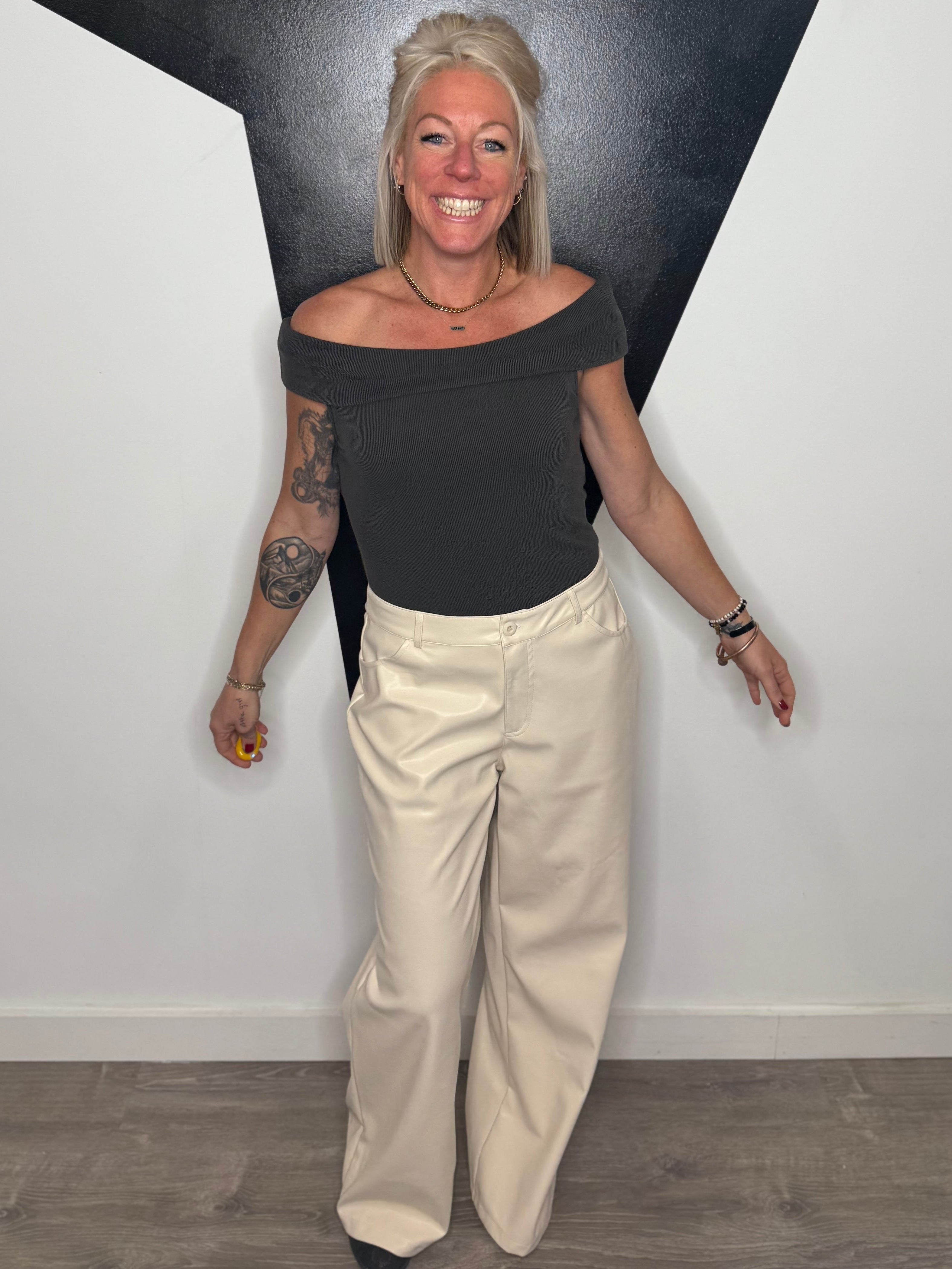 Woman standing against a black and white geometric wall.