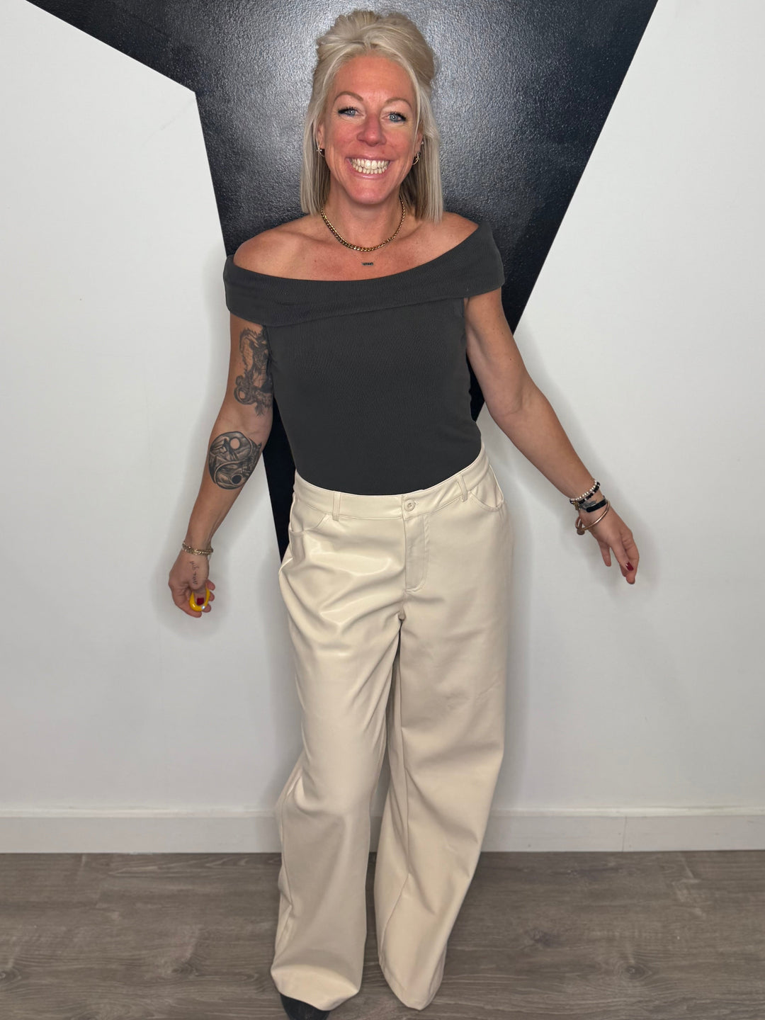 Woman standing against a black and white geometric wall.