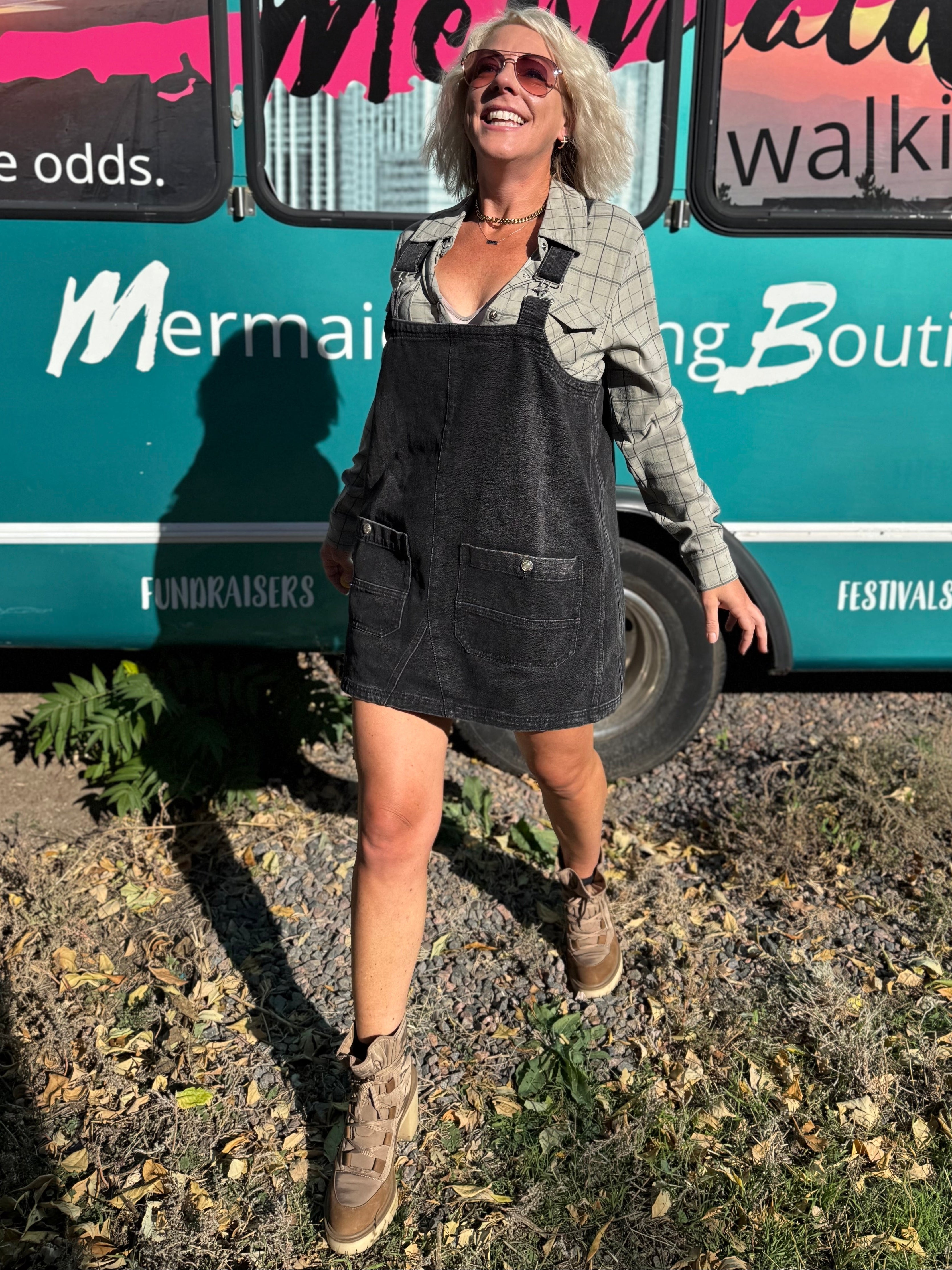 Woman standing in front of a teal bus with 'Mermaid Walking' branding.