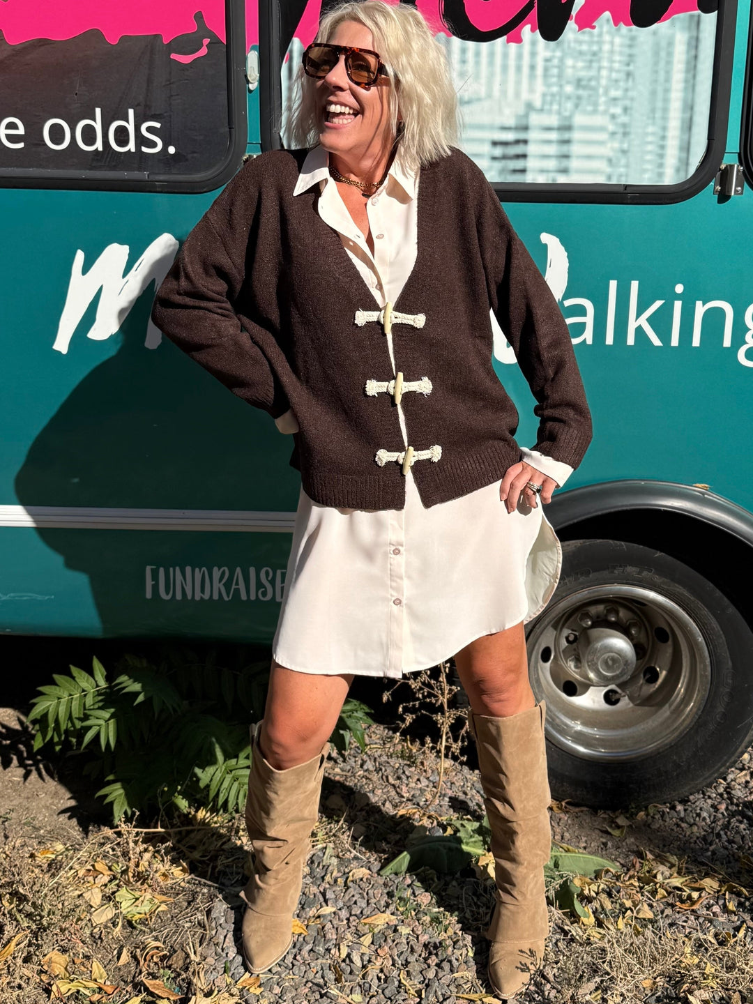 Woman standing in front of a teal bus with &