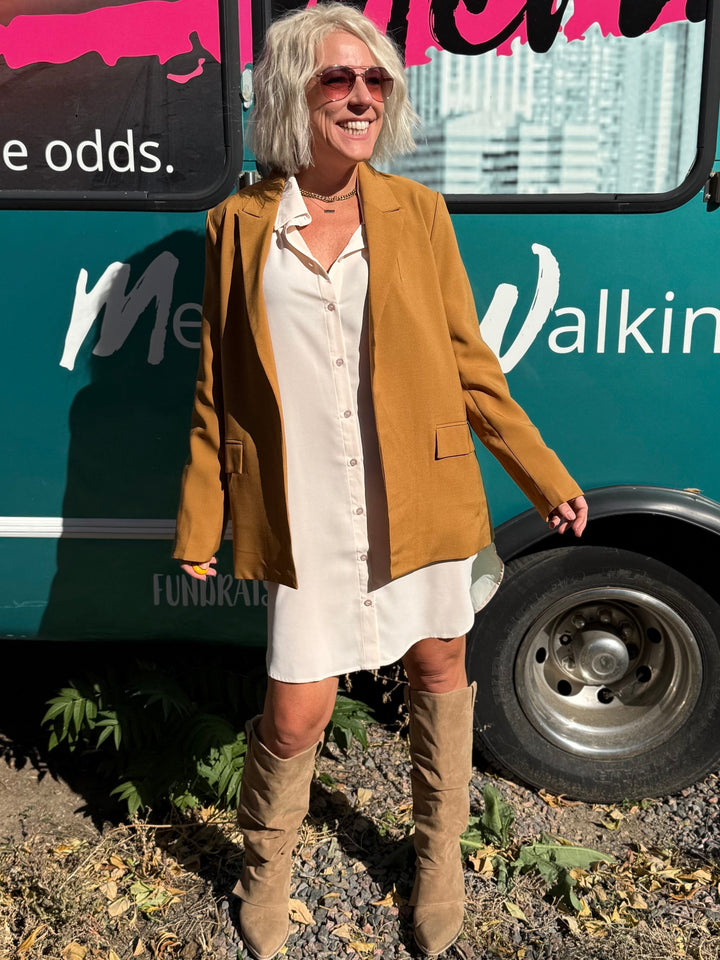 Woman standing in front of a teal bus with &