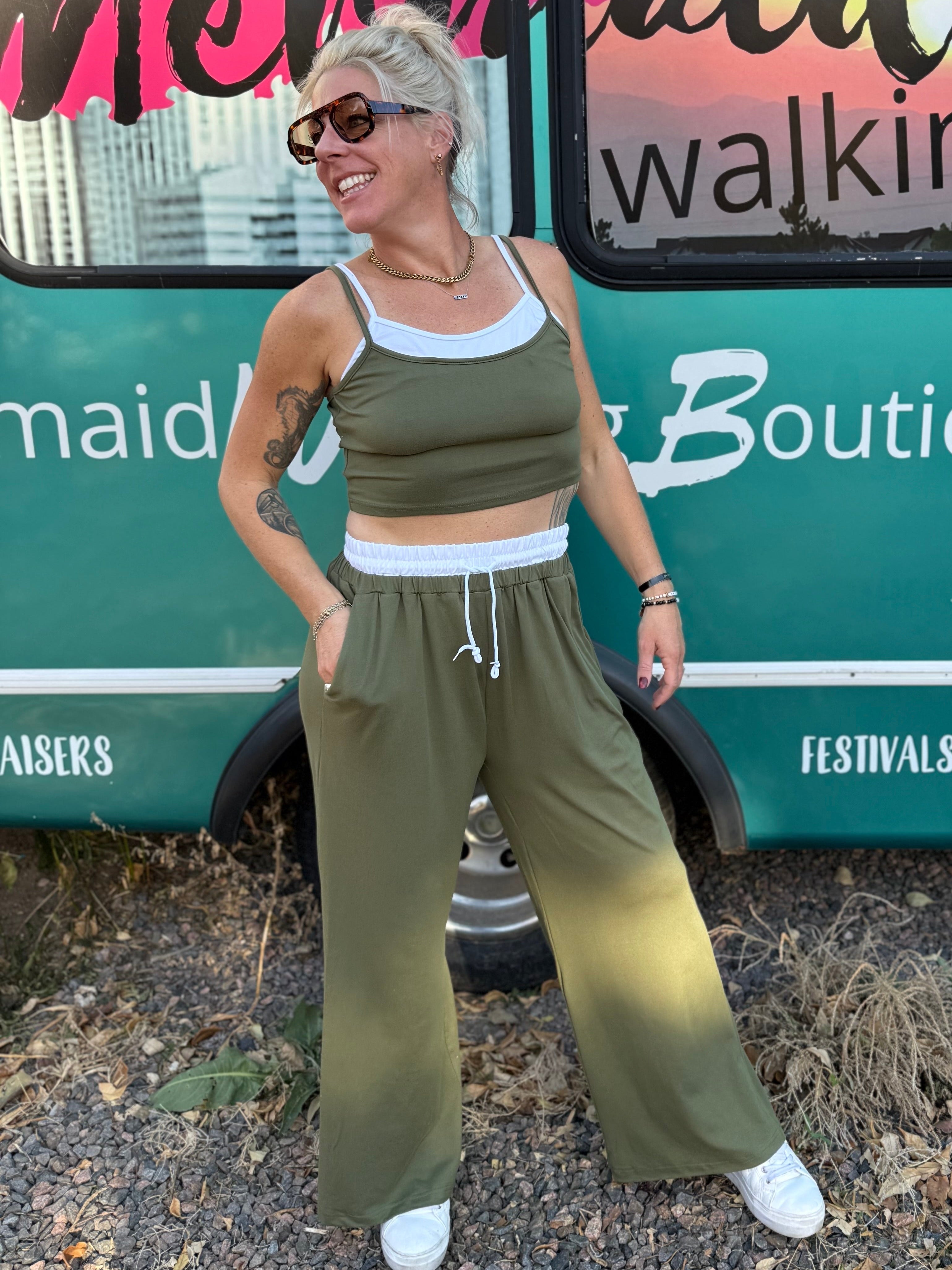 Woman in green outfit standing in front of a branded bus.
