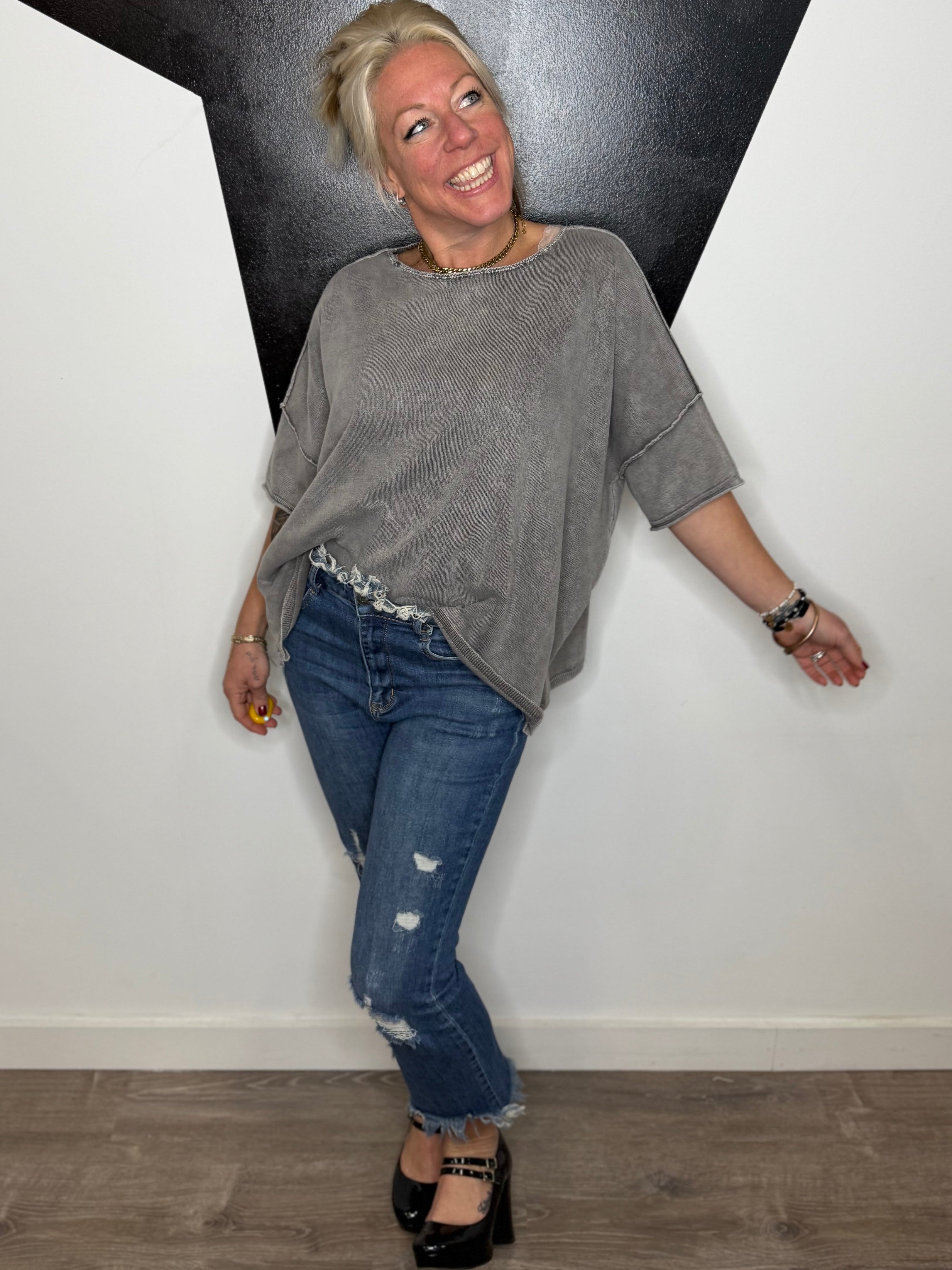 Woman leaning against a wall with a black and white geometric design