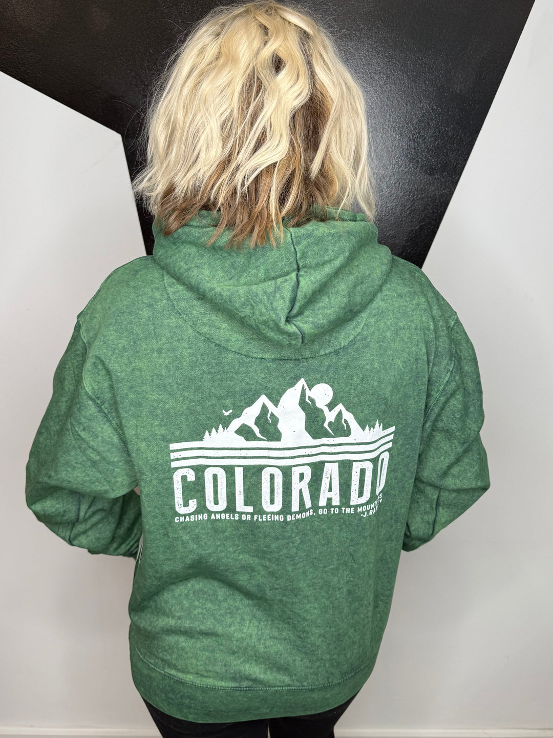 Person wearing a green hoodie with &