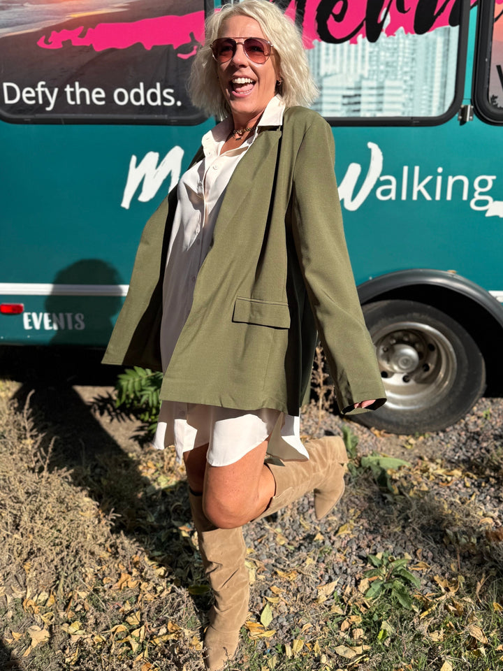 Woman standing in front of a teal bus with &
