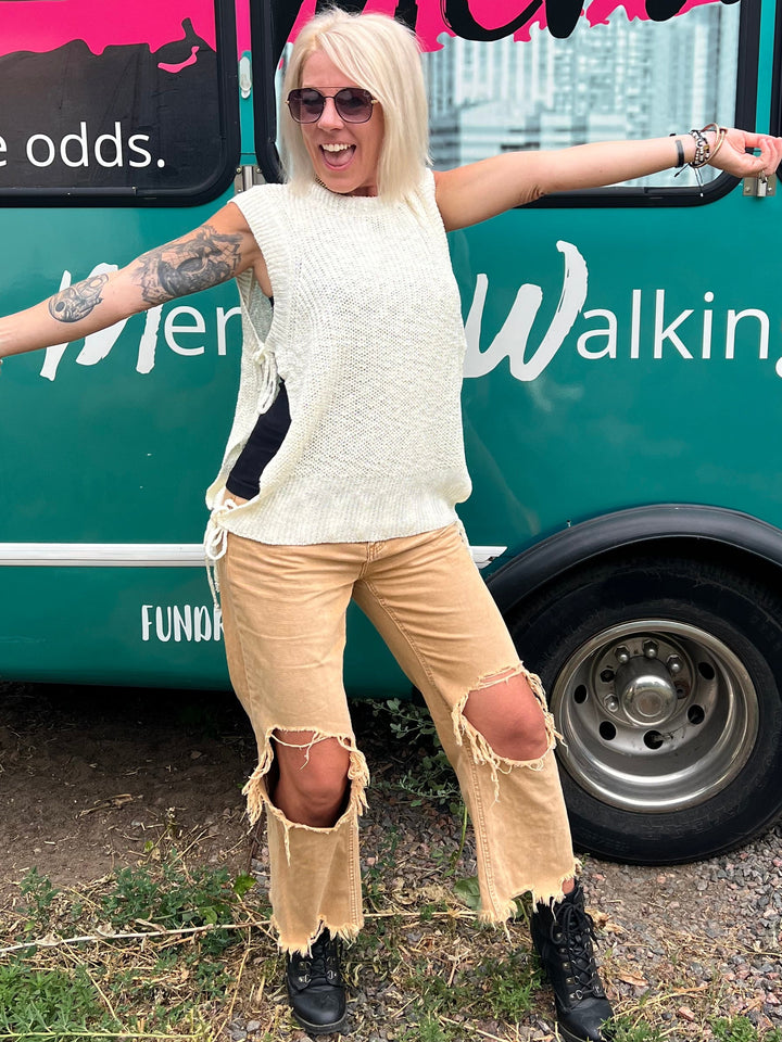 Person standing next to a bus with promotional graphics on a grassy area