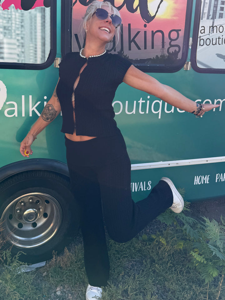 A woman posing in front of a green mobile boutique bus with &