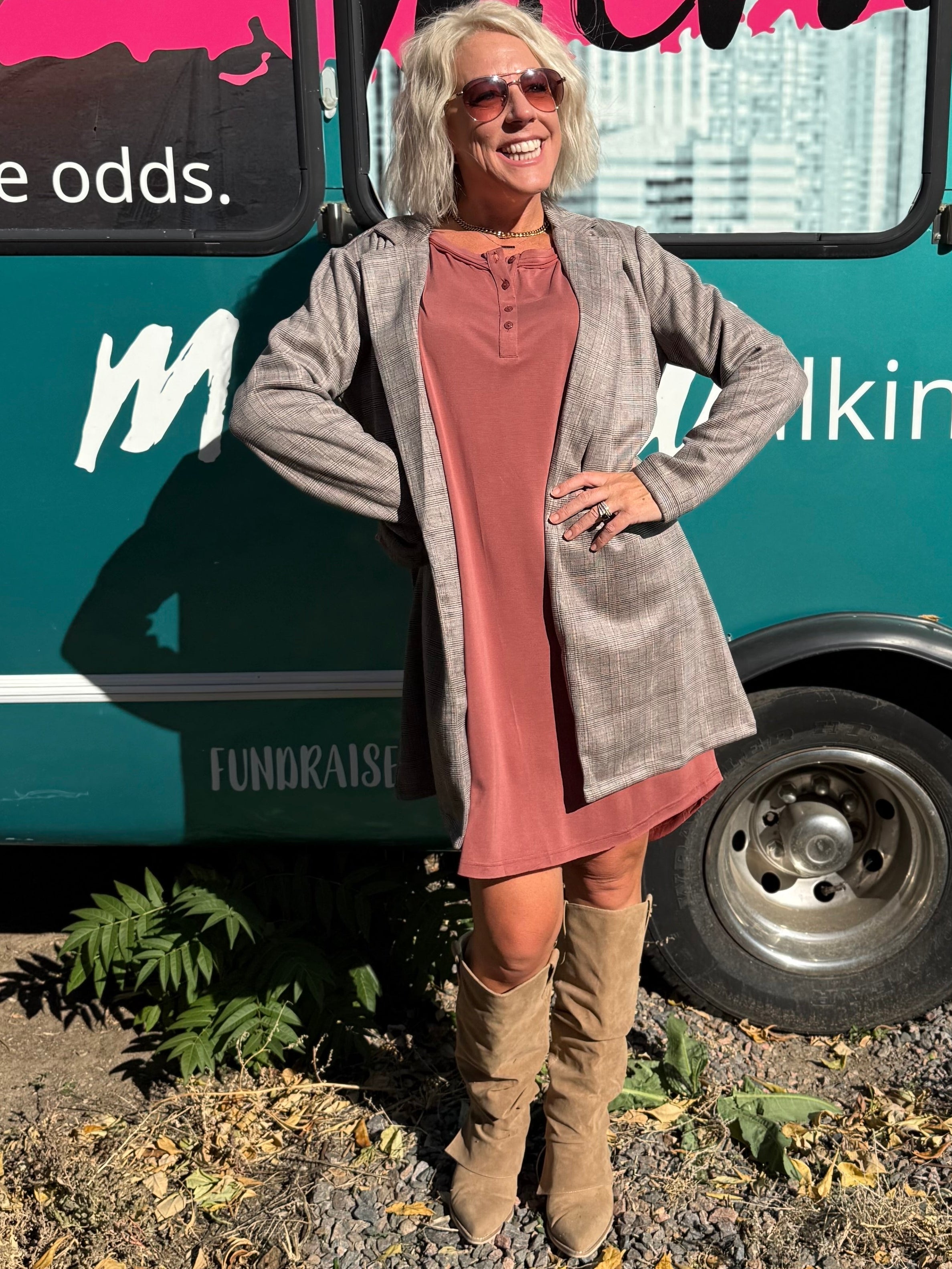 Woman standing in front of a teal bus with 'Mermaid Walking' branding.