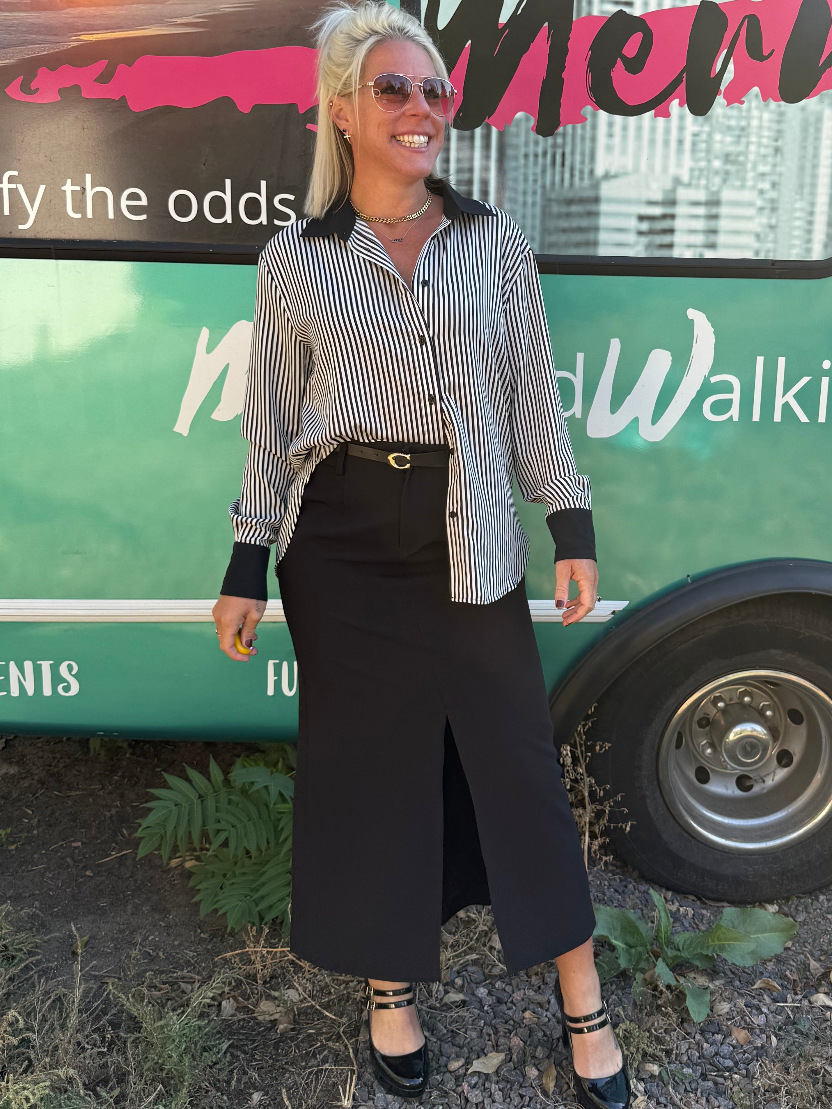 Person standing in front of a colorful bus with text and graphics.