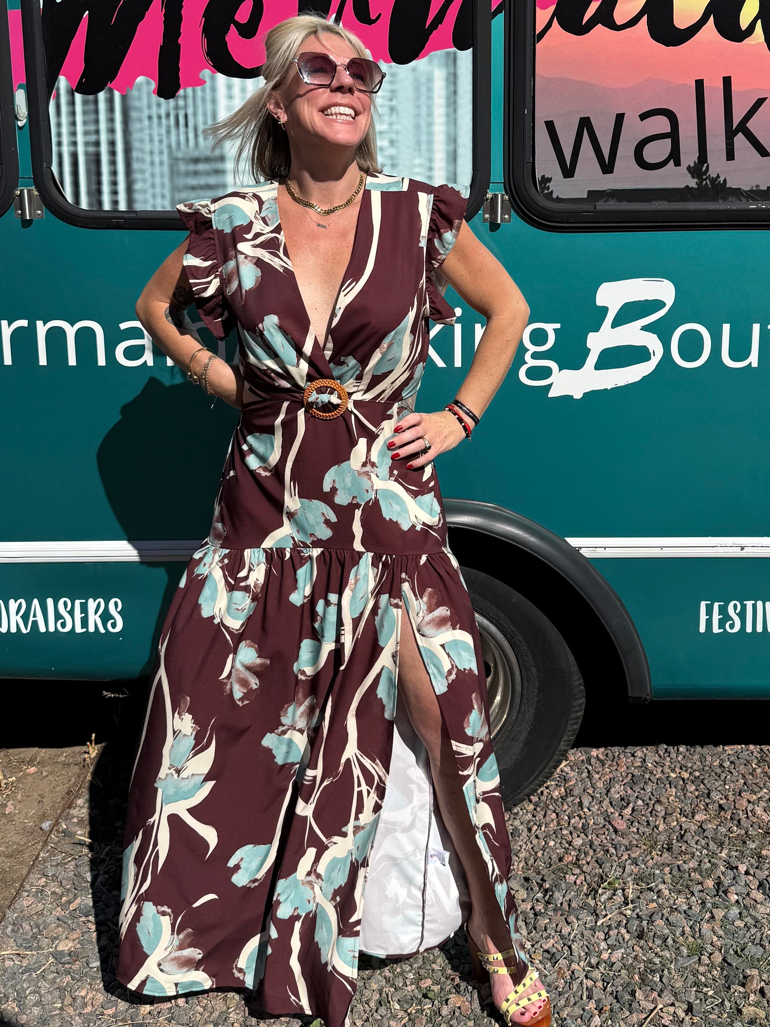 Woman in a patterned dress standing next to a bus with 'Mermaid Walking' branding.