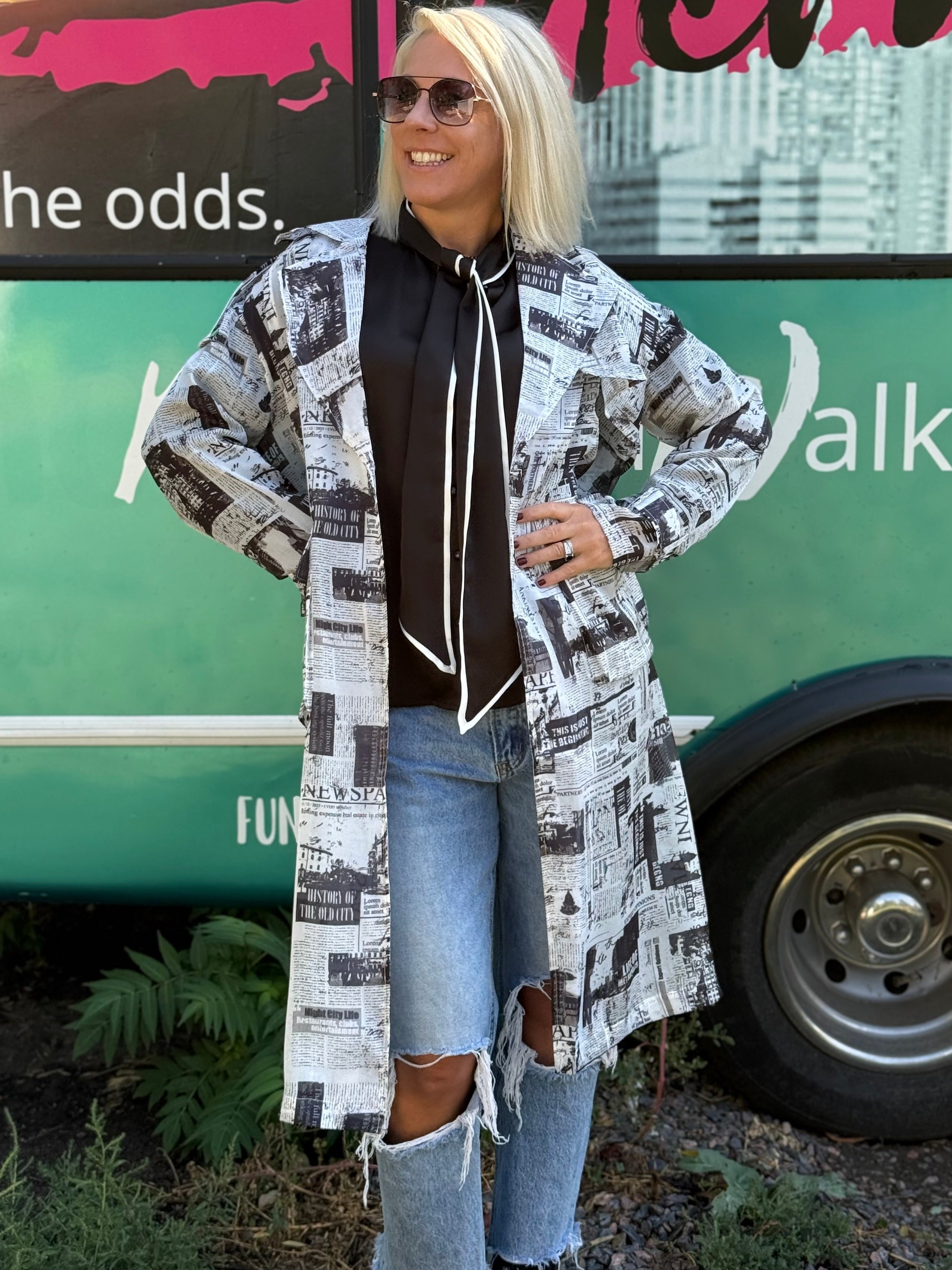 Woman standing in front of a green bus with text and graphics.