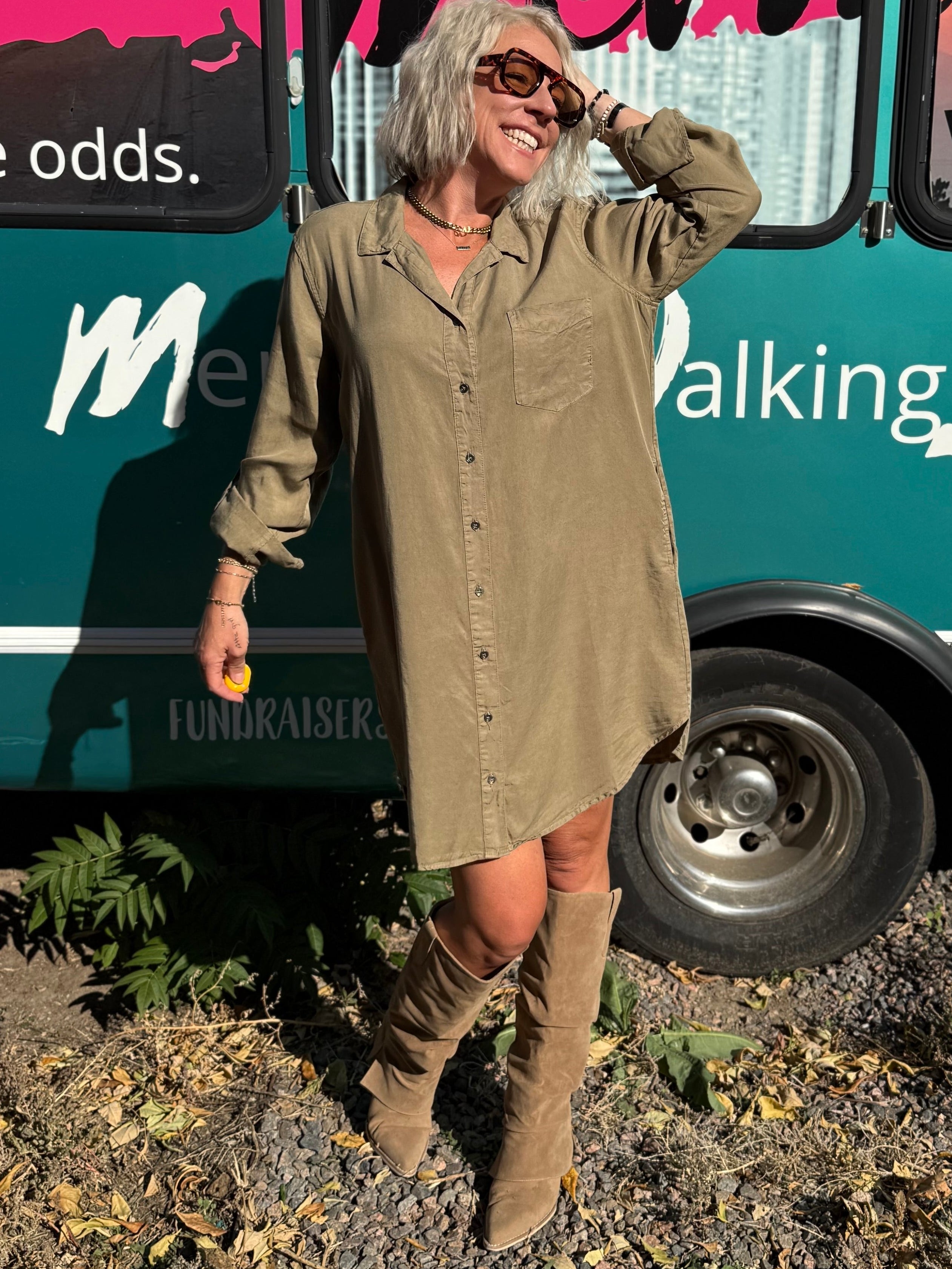 Woman standing in front of a teal bus with 'Mermaid Walking' branding.