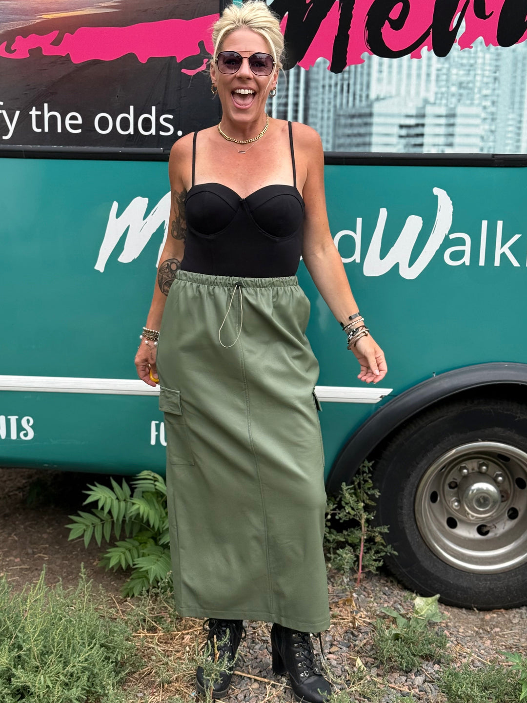 Woman standing in front of a branded vehicle with text &