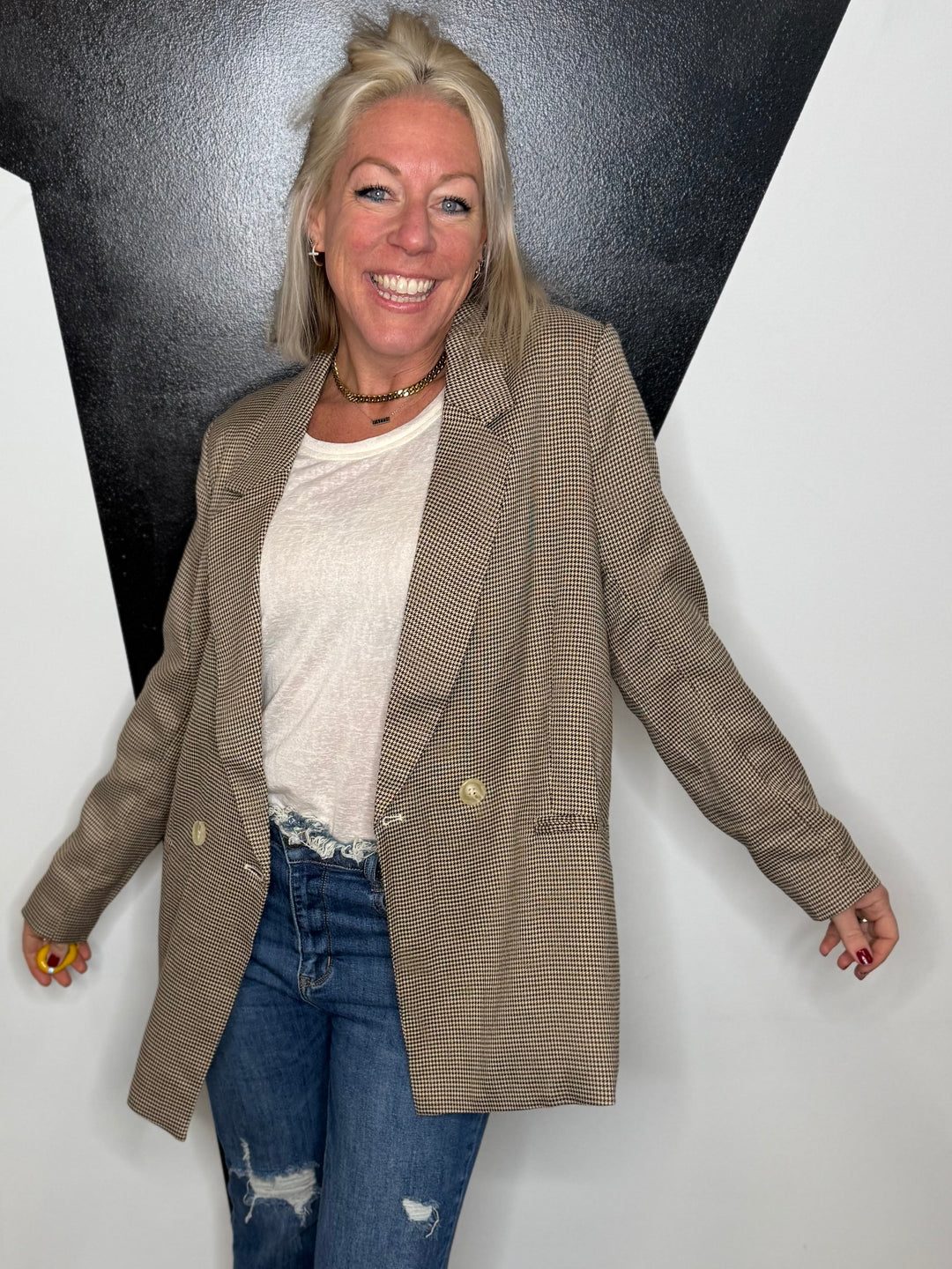 Woman standing in a room with a black and white geometric wall design.