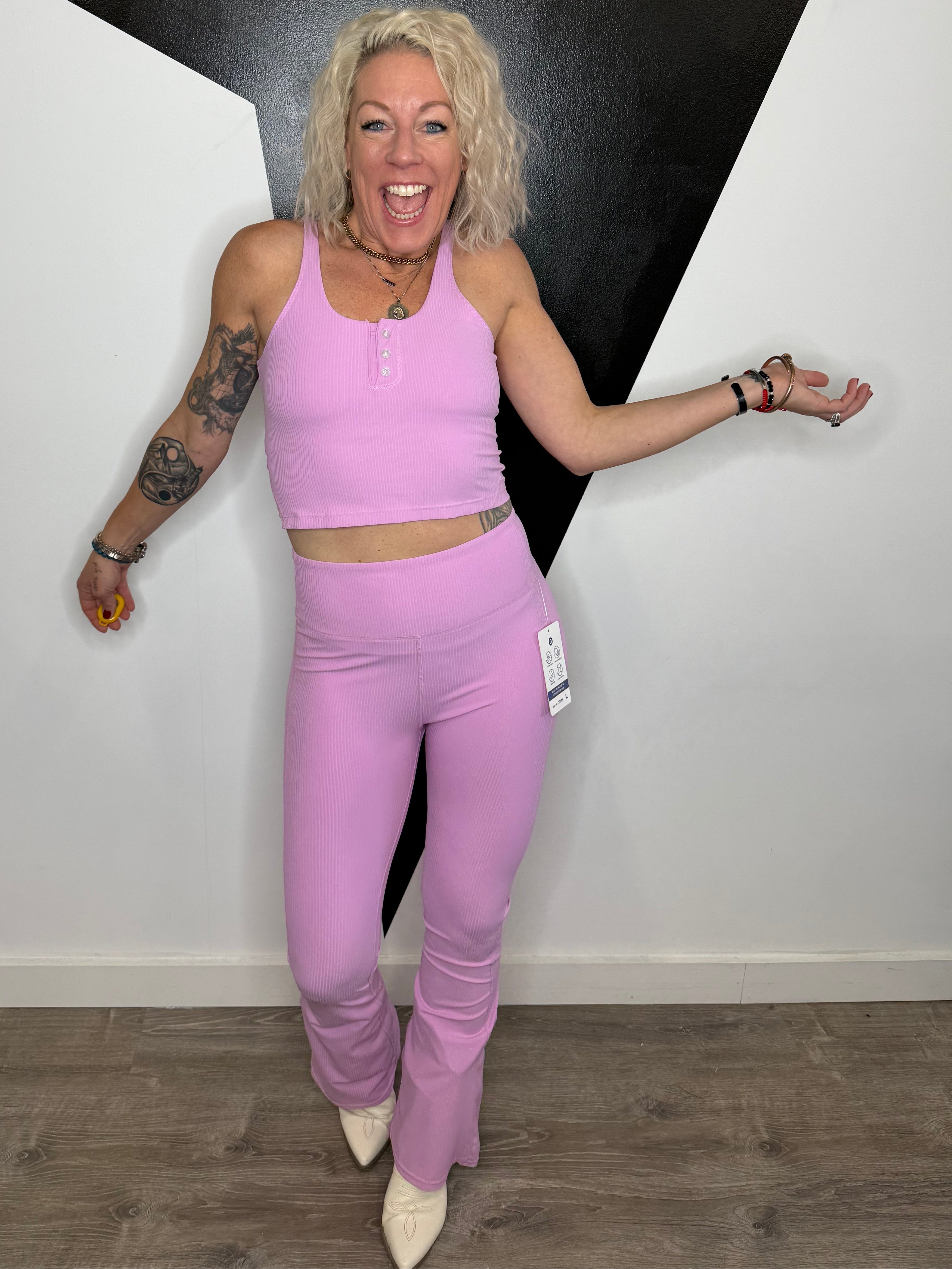 Person wearing pink athletic wear on a black and white floor.