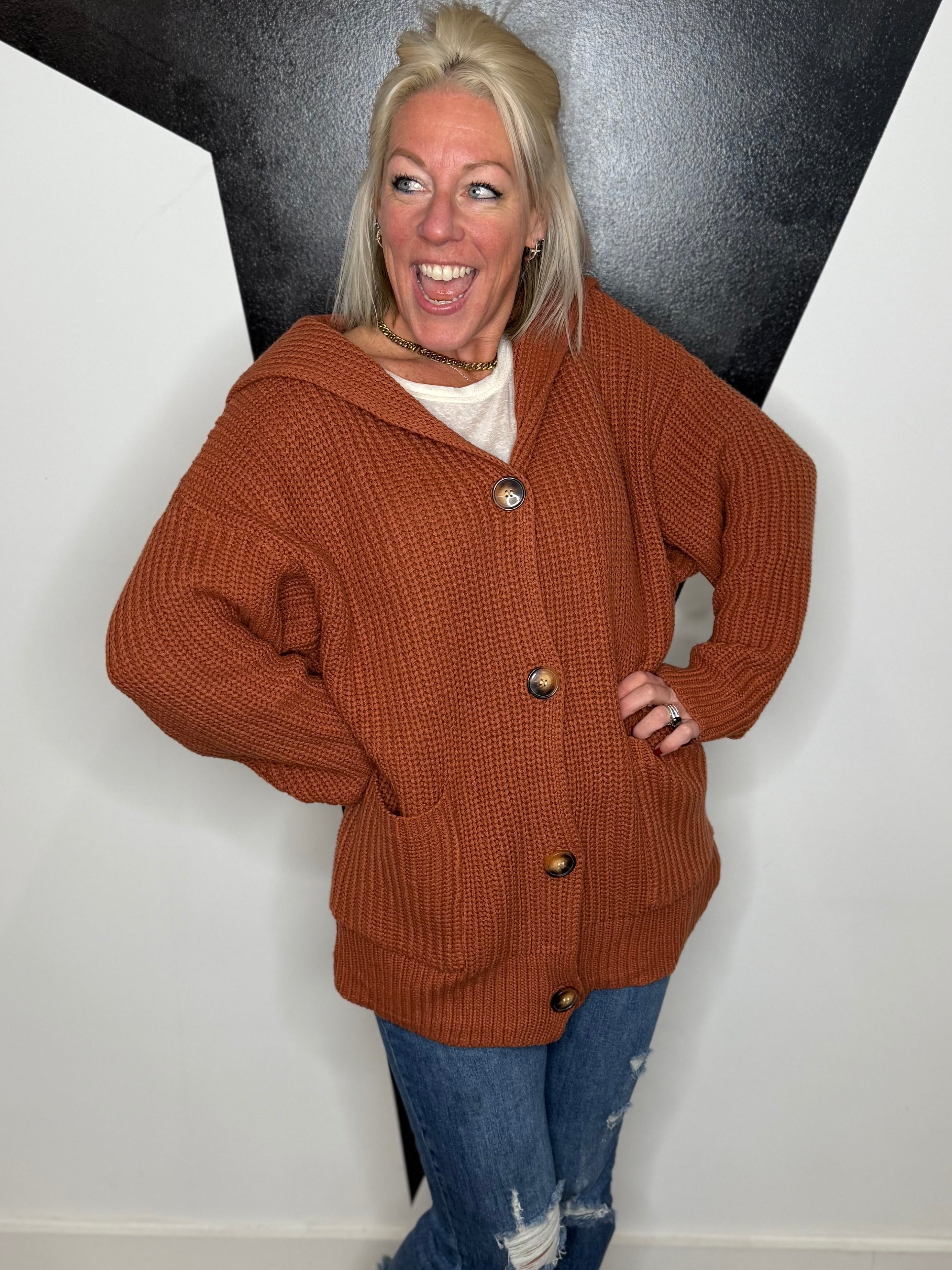 Person wearing a brown jacket with a black and white geometric wall background