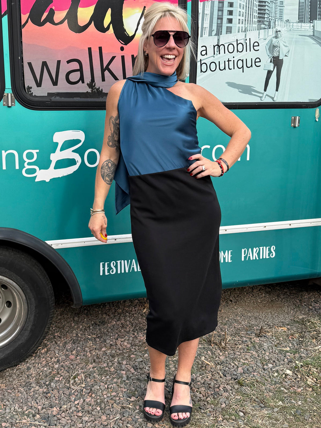 Person standing next to a teal vehicle with &