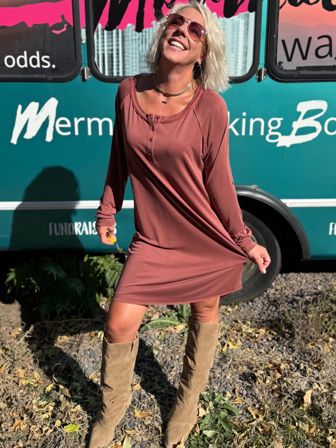 Woman standing in front of a teal bus with &