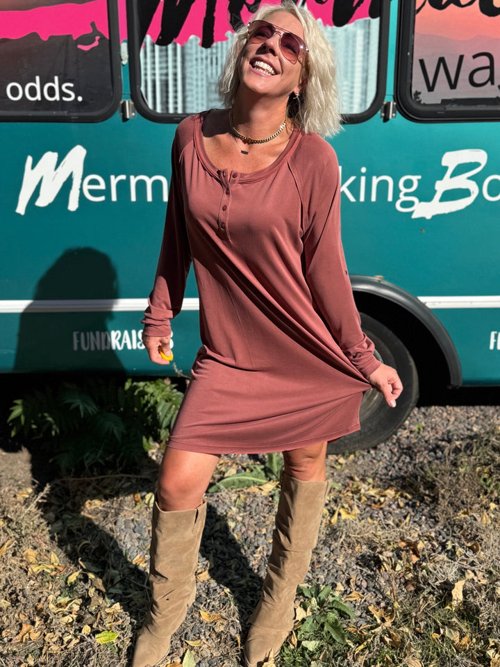 Woman standing in front of a teal bus with &