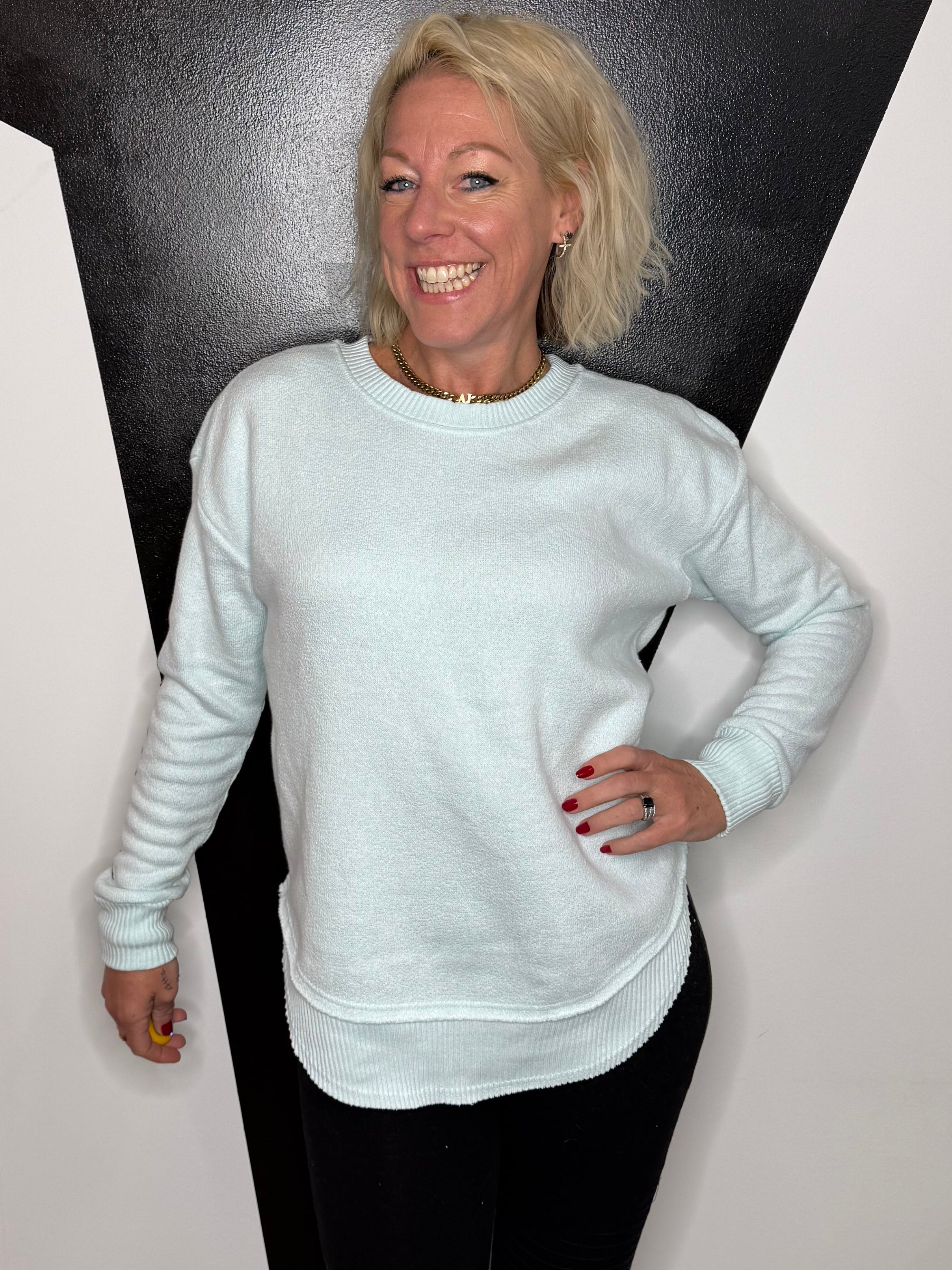 Person standing on a black and white floor with a light source above.
