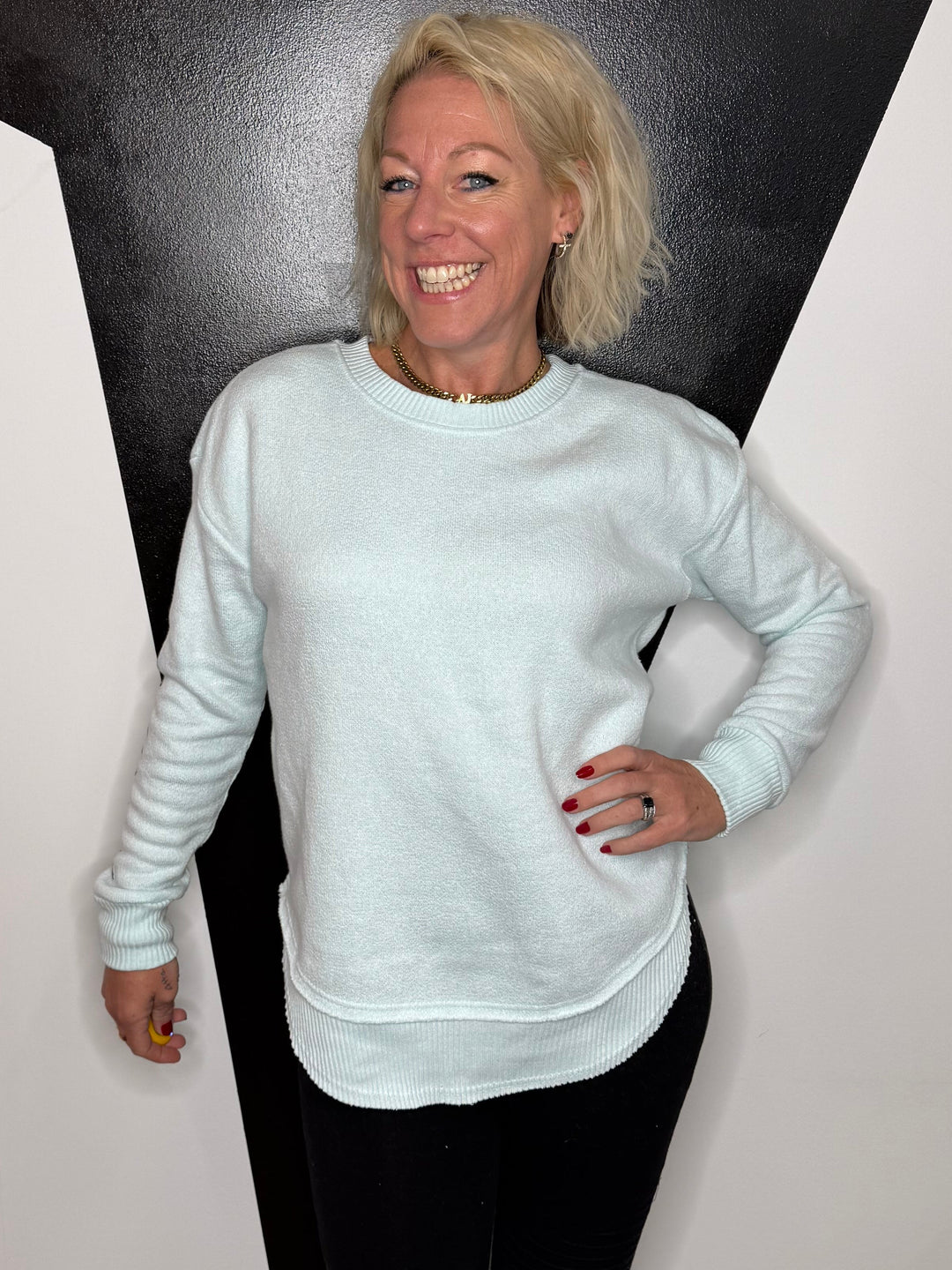 Person standing on a black and white floor with a light source above.